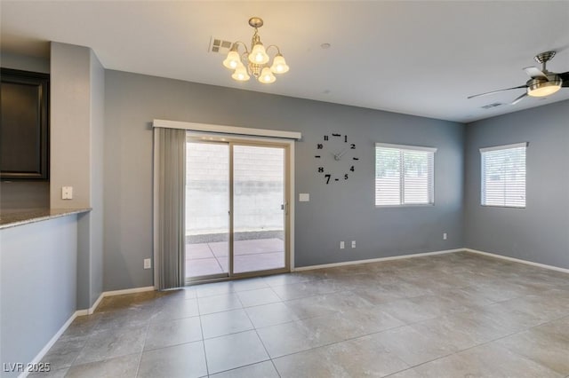 empty room with a chandelier, ceiling fan, baseboards, and light tile patterned floors