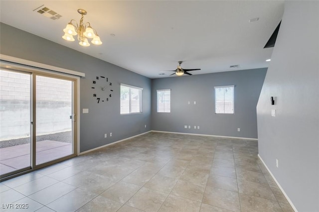 unfurnished room with plenty of natural light, a chandelier, ceiling fan, and baseboards