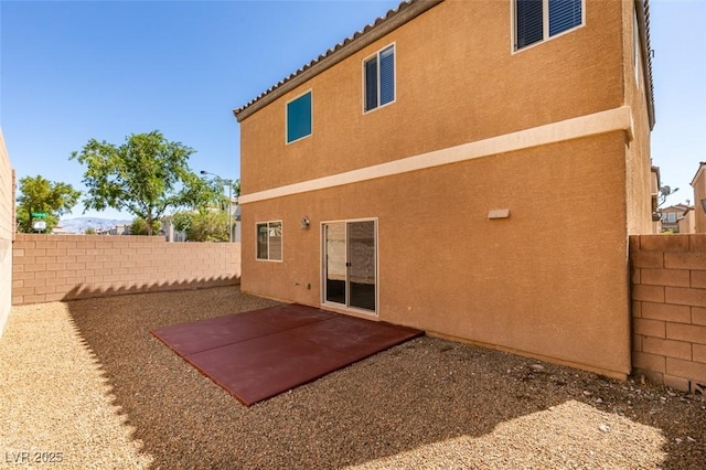 back of house with stucco siding, a fenced backyard, and a patio area