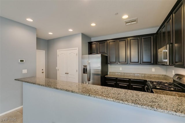 kitchen with appliances with stainless steel finishes, light stone counters, recessed lighting, light tile patterned floors, and baseboards