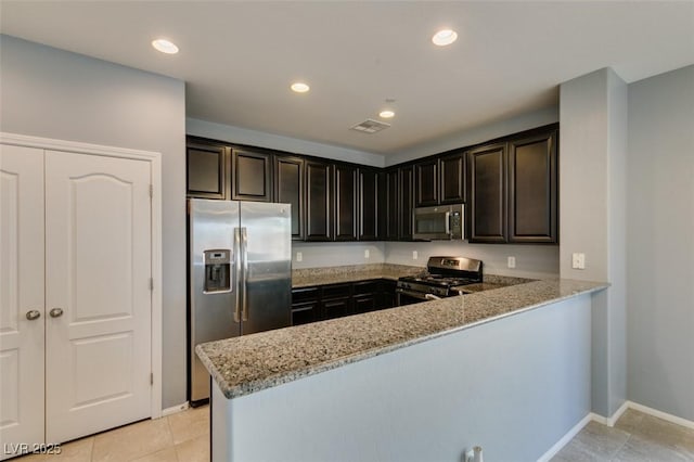 kitchen featuring stainless steel appliances, a peninsula, light stone countertops, light tile patterned flooring, and baseboards