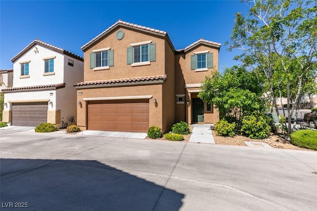 view of front of property featuring an attached garage, a tiled roof, concrete driveway, and stucco siding