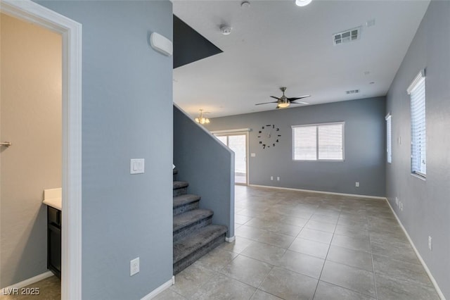stairs featuring a ceiling fan, tile patterned floors, and baseboards