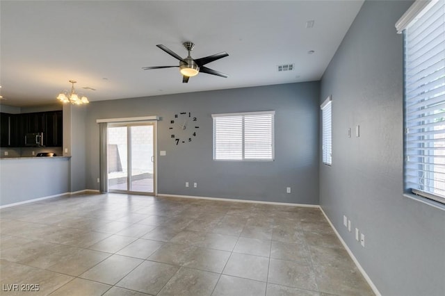 unfurnished living room with a chandelier, plenty of natural light, a ceiling fan, and light tile patterned flooring