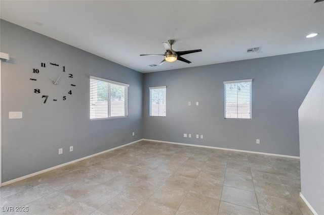 spare room with a ceiling fan and baseboards