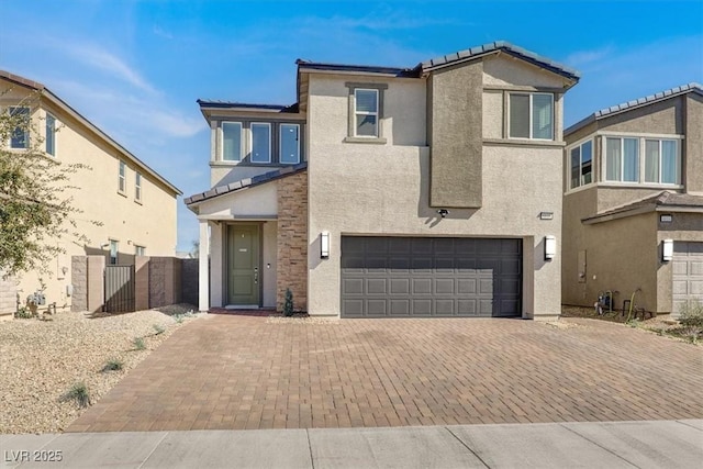 view of front facade featuring stucco siding, decorative driveway, and a garage