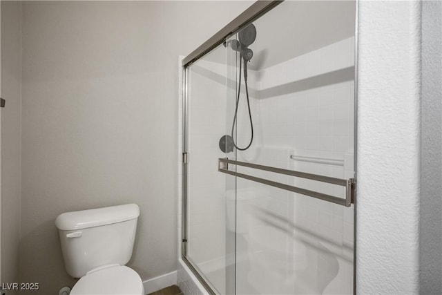 bathroom with a stall shower and toilet