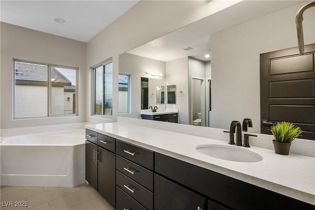 bathroom with a garden tub, tile patterned floors, toilet, a stall shower, and vanity