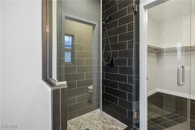bathroom with a stall shower and a spacious closet