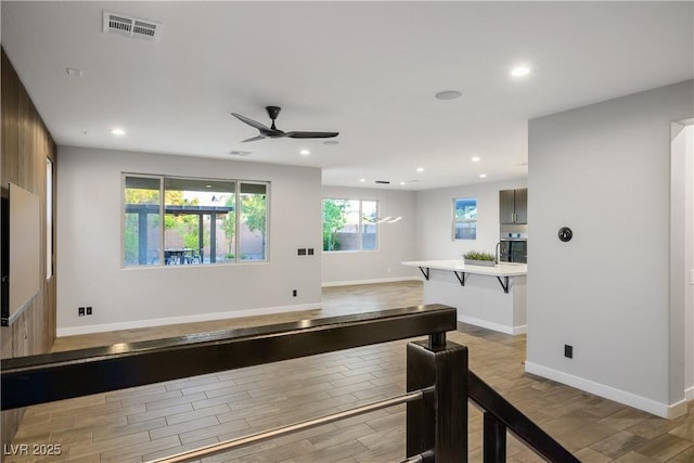 rec room with light wood-style flooring, ceiling fan, recessed lighting, and baseboards