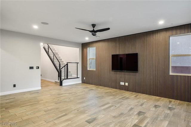 unfurnished living room with ceiling fan, stairs, wood finished floors, recessed lighting, and baseboards