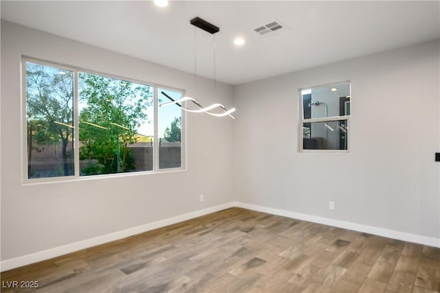 spare room featuring wood finished floors, baseboards, and recessed lighting