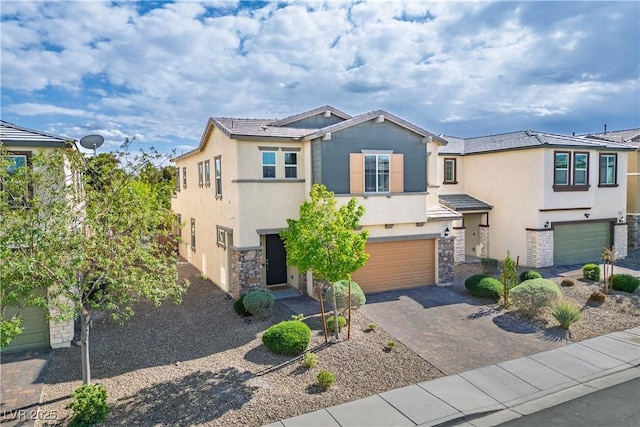 view of front of house featuring an attached garage, stucco siding, stone siding, and driveway
