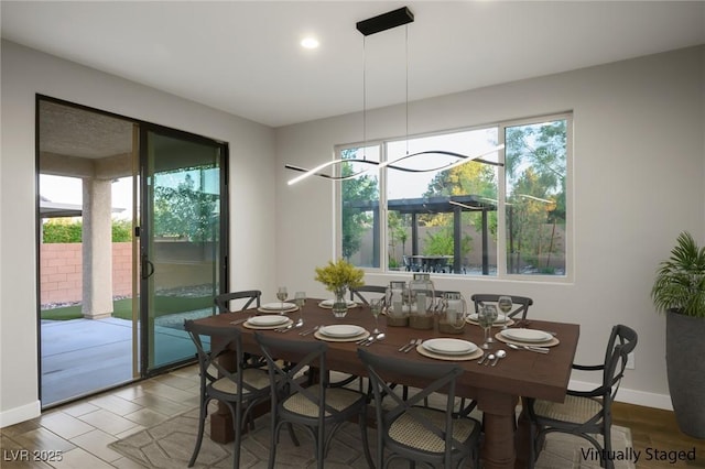 dining room featuring baseboards, wood finished floors, and recessed lighting
