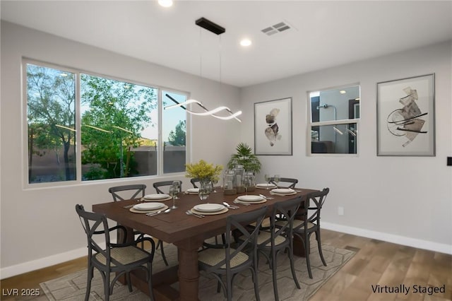 dining area featuring baseboards, wood finished floors, and recessed lighting