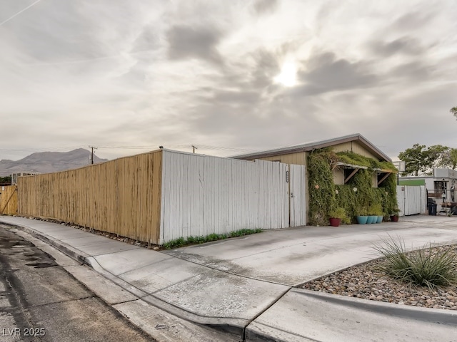 view of side of property with fence and a mountain view
