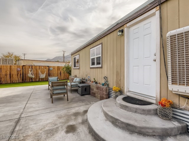 entrance to property featuring fence, an outdoor living space, and a patio area