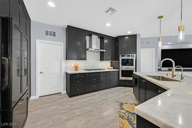 3171 Biccari Ave, Henderson, NV 89044 - kitchen featuring appliances with stainless steel finishes, wall chimney range hood, a sink, dark cabinets, and recessed lighting