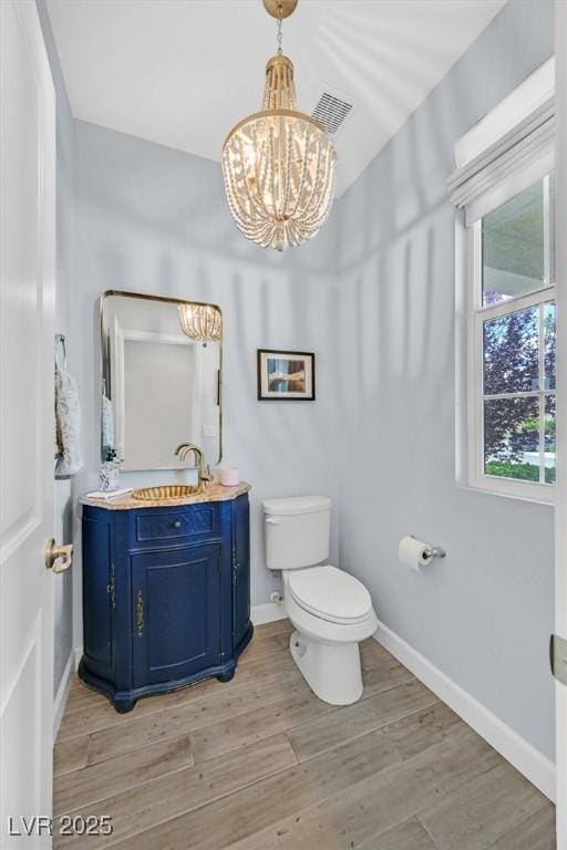 3171 Biccari Ave, Henderson, NV 89044 - bathroom with a chandelier, toilet, baseboards, wood finished floors, and vanity