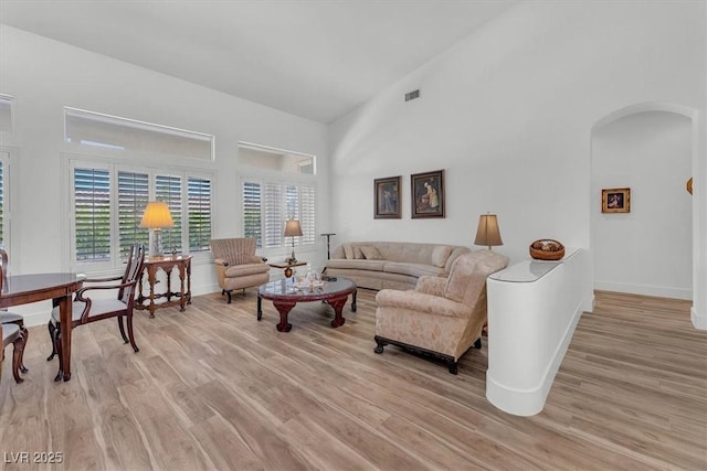 9916 Netherton Dr, Las Vegas, NV 89134 - living room with arched walkways, light wood-type flooring, baseboards, and a towering ceiling
