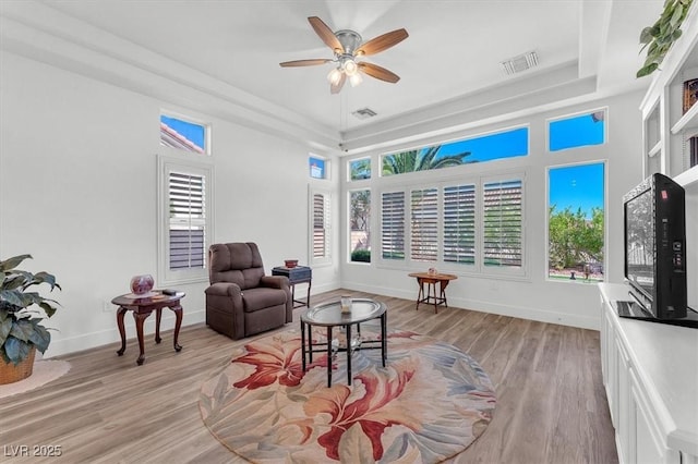 9916 Netherton Dr, Las Vegas, NV 89134 - living room featuring a raised ceiling, healthy amount of natural light, a ceiling fan, and baseboards