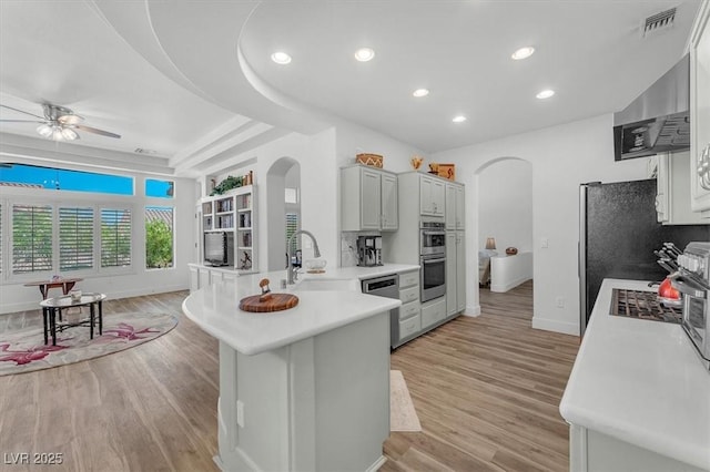 9916 Netherton Dr, Las Vegas, NV 89134 - kitchen featuring arched walkways, appliances with stainless steel finishes, a sink, a peninsula, and recessed lighting