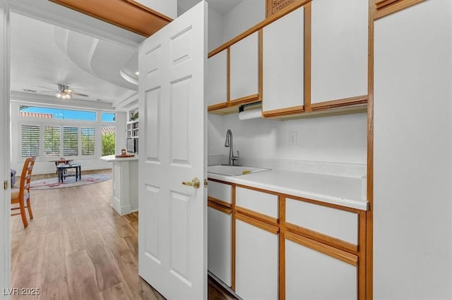 9916 Netherton Dr, Las Vegas, NV 89134 - kitchen featuring white cabinetry, light countertops, ceiling fan, light wood-style floors, and a sink