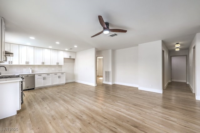 kitchen with stainless steel dishwasher, ceiling fan, white cabinetry, baseboards, and light countertops