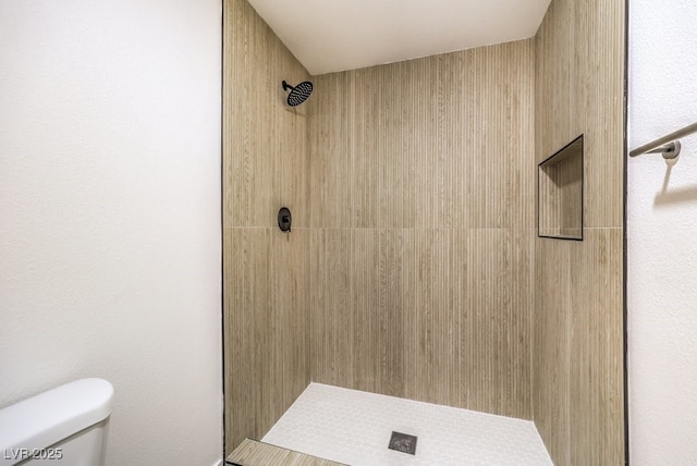 bathroom with tiled shower and toilet