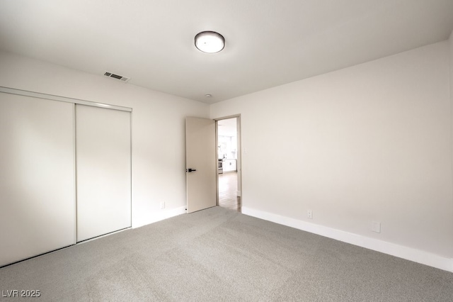 unfurnished bedroom featuring carpet flooring, a closet, and baseboards