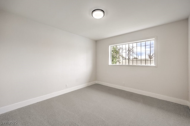 spare room featuring baseboards and carpet floors