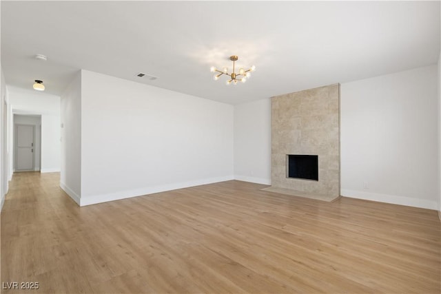 4450 San Rafael Ave, Las Vegas, NV 89120 - unfurnished living room featuring a chandelier, light wood finished floors, baseboards, and a tile fireplace