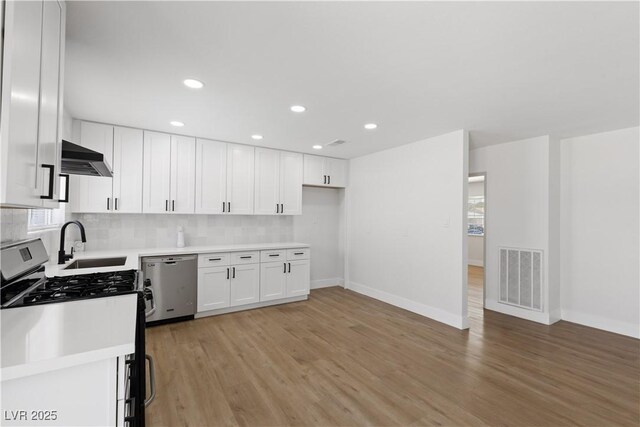4450 San Rafael Ave, Las Vegas, NV 89120 - kitchen featuring appliances with stainless steel finishes, a sink, white cabinets, tasteful backsplash, and recessed lighting