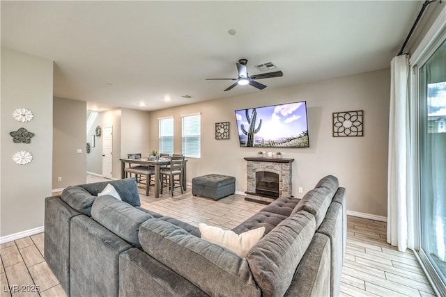 1267 Dorado Sea Ct, Henderson, NV 89052 - living area featuring wood tiled floors, a ceiling fan, baseboards, and a fireplace
