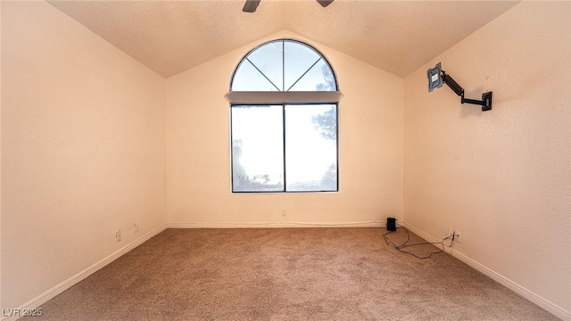 unfurnished room with lofted ceiling, carpet floors, a ceiling fan, baseboards, and a textured ceiling