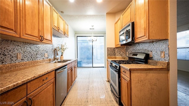 kitchen featuring stainless steel appliances, a sink, tasteful backsplash, hanging light fixtures, and brown cabinets