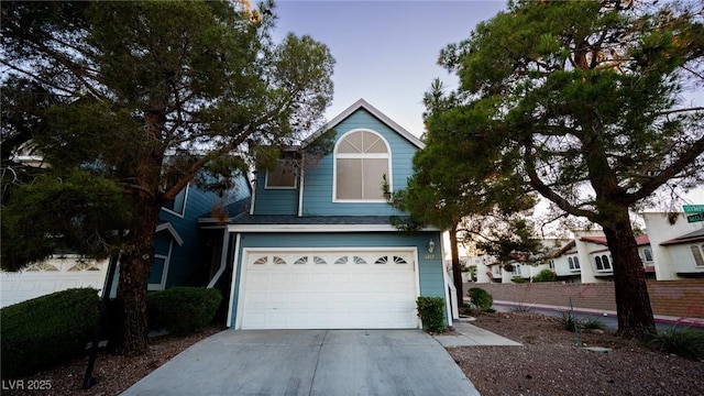 view of front facade with driveway, a garage, and fence