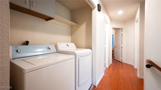 laundry area featuring light wood-style floors, separate washer and dryer, and baseboards
