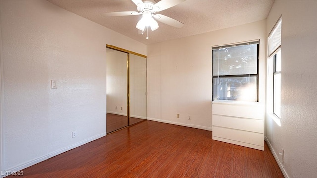 unfurnished bedroom featuring wood finished floors, a closet, and baseboards