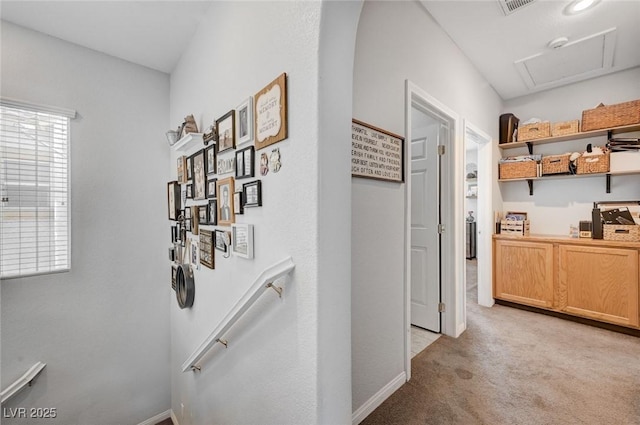 hallway featuring light carpet, an upstairs landing, and baseboards