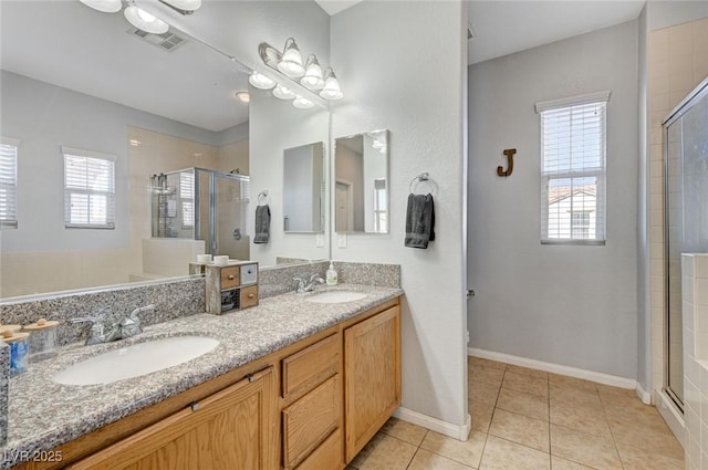 bathroom with a stall shower, tile patterned flooring, double vanity, baseboards, and toilet