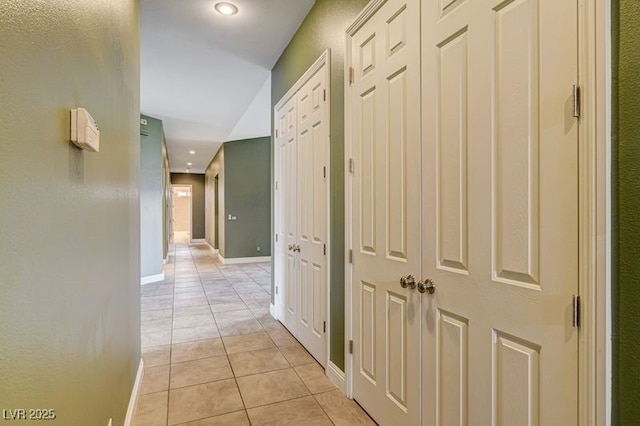 hall with light tile patterned floors, baseboards, and recessed lighting