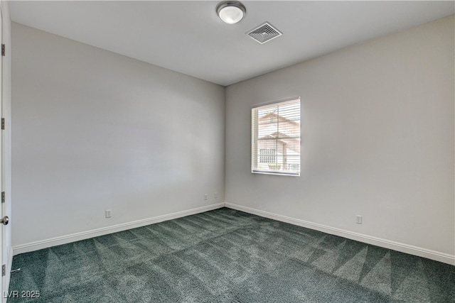 spare room featuring dark carpet and baseboards