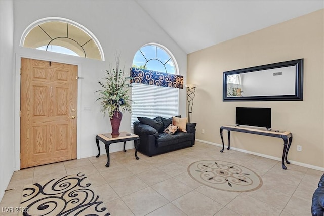 tiled entryway with high vaulted ceiling and baseboards
