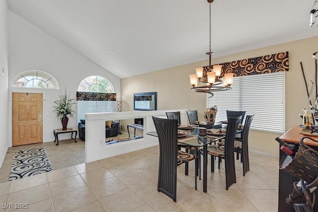dining space with a chandelier, light tile patterned flooring, and high vaulted ceiling