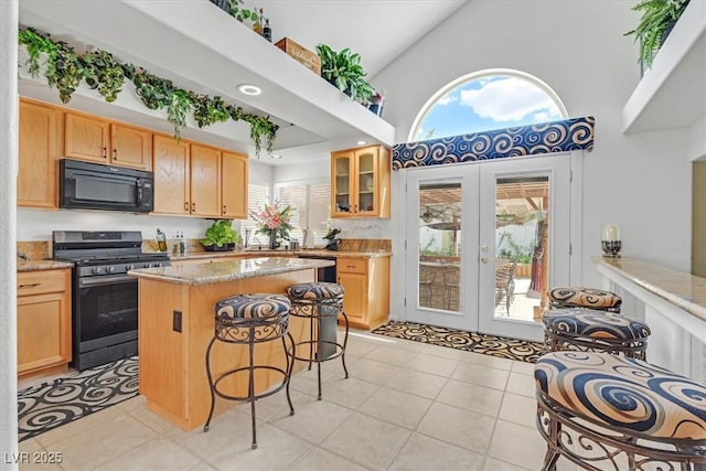 kitchen with black microwave, gas range, french doors, high vaulted ceiling, and healthy amount of natural light
