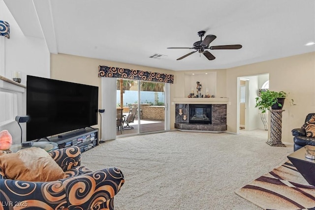 carpeted living area featuring ceiling fan, a fireplace, and baseboards
