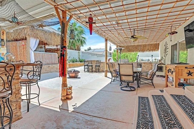 view of patio / terrace featuring outdoor dining area, ceiling fan, fence, and a pergola