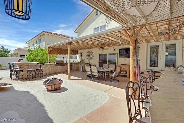 view of patio / terrace with an outdoor bar, french doors, an outdoor fire pit, exterior kitchen, and fence