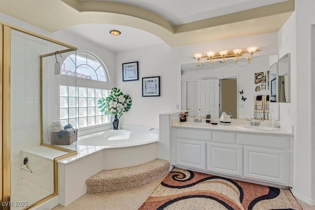 bathroom featuring a stall shower, a garden tub, double vanity, and a chandelier